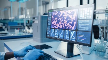 A person working on a computer showing genetic data.