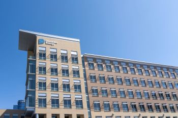 A building with the Dominion Energy logo and multiple windows against a clear blue sky.