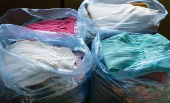 Bags filled with assorted clothing items in various colors.