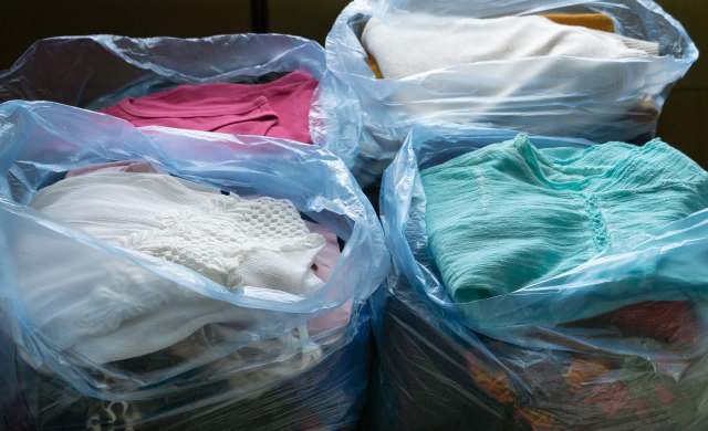 Bags filled with assorted clothing items in various colors.