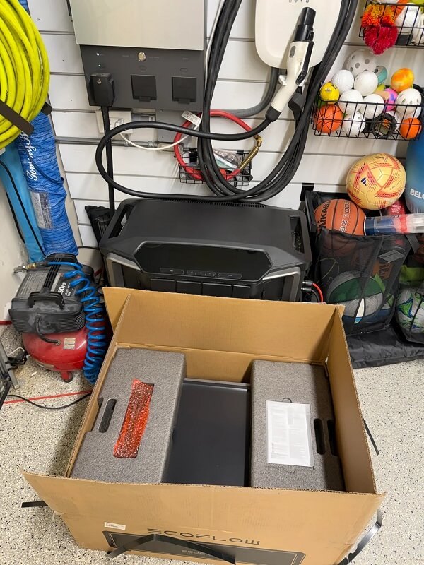 A garage storage area filled with various sports equipment, tools, and a portable power station.
