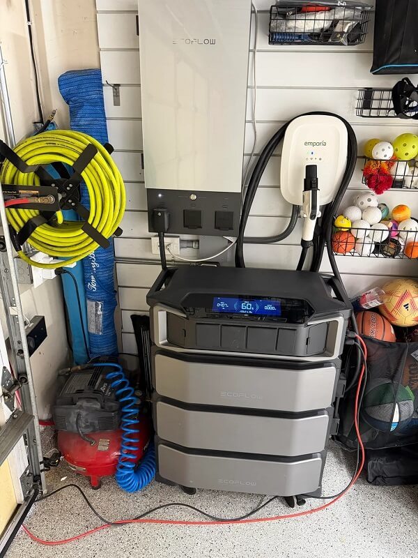 A garage storage area filled with various sports equipment, tools, and a portable power station.