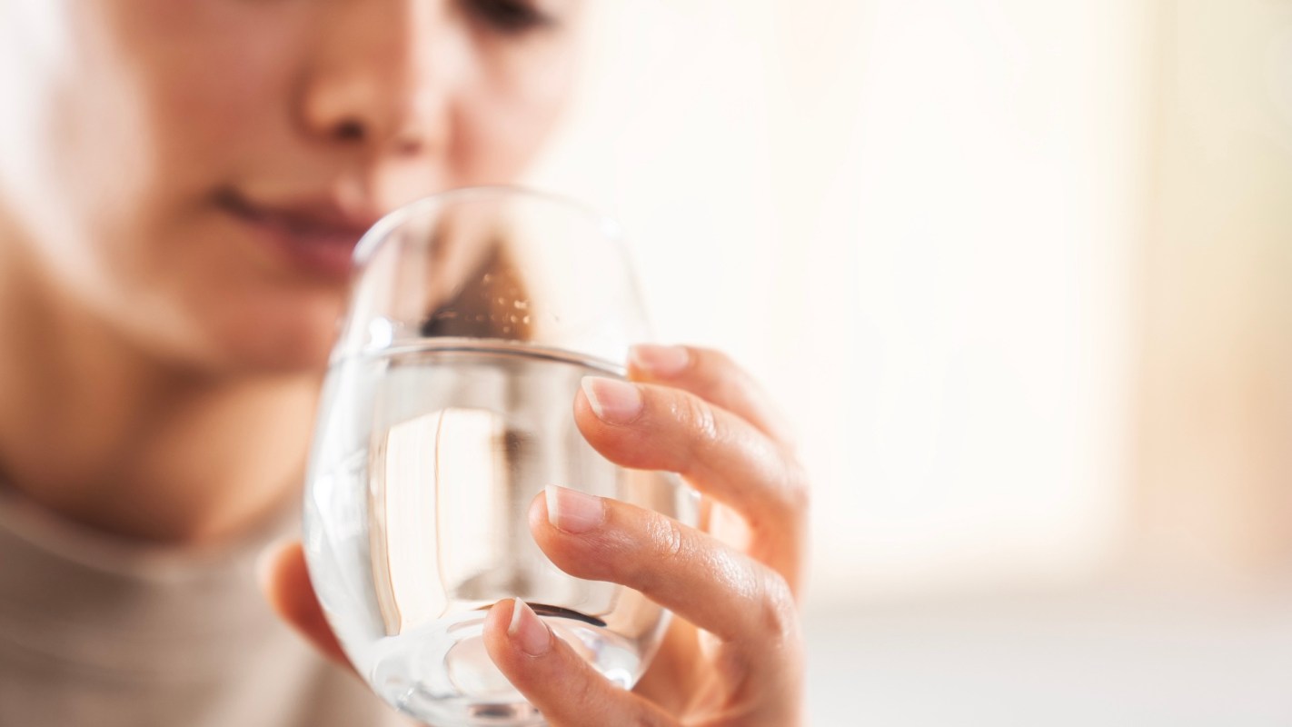 A person holding a glass of water.