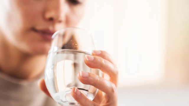 A person holding a glass of water.