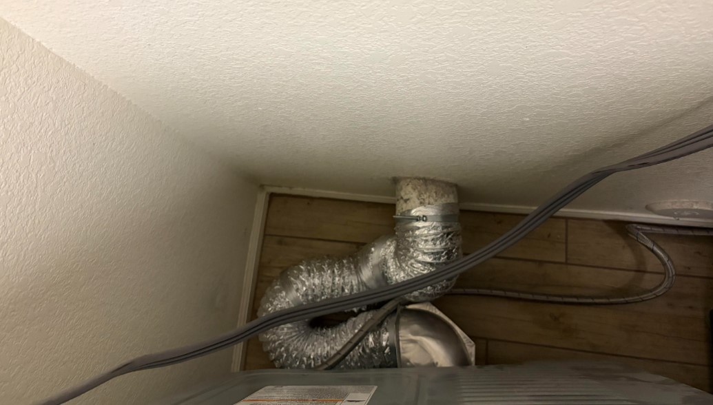 A duct behind a dryer. 