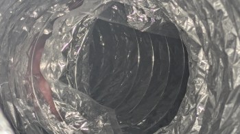 A circular duct with a metallic, crinkled texture.