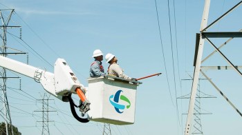 Two Duke Energy workers looking at power lines.
