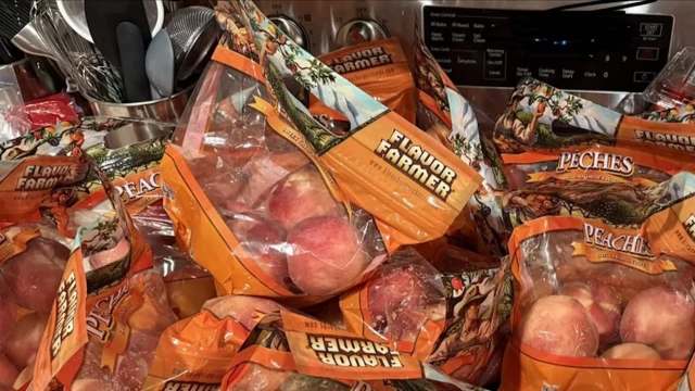 Bags of peaches labeled "Flavor Farmer" piled together on a counter.