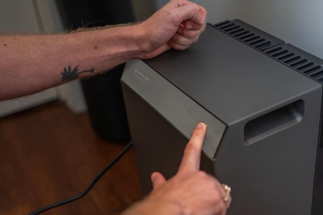 A person interacts with a portable air conditioner unit.