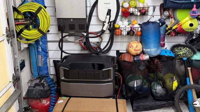 A garage storage area filled with various sports equipment, tools, and a portable power station.