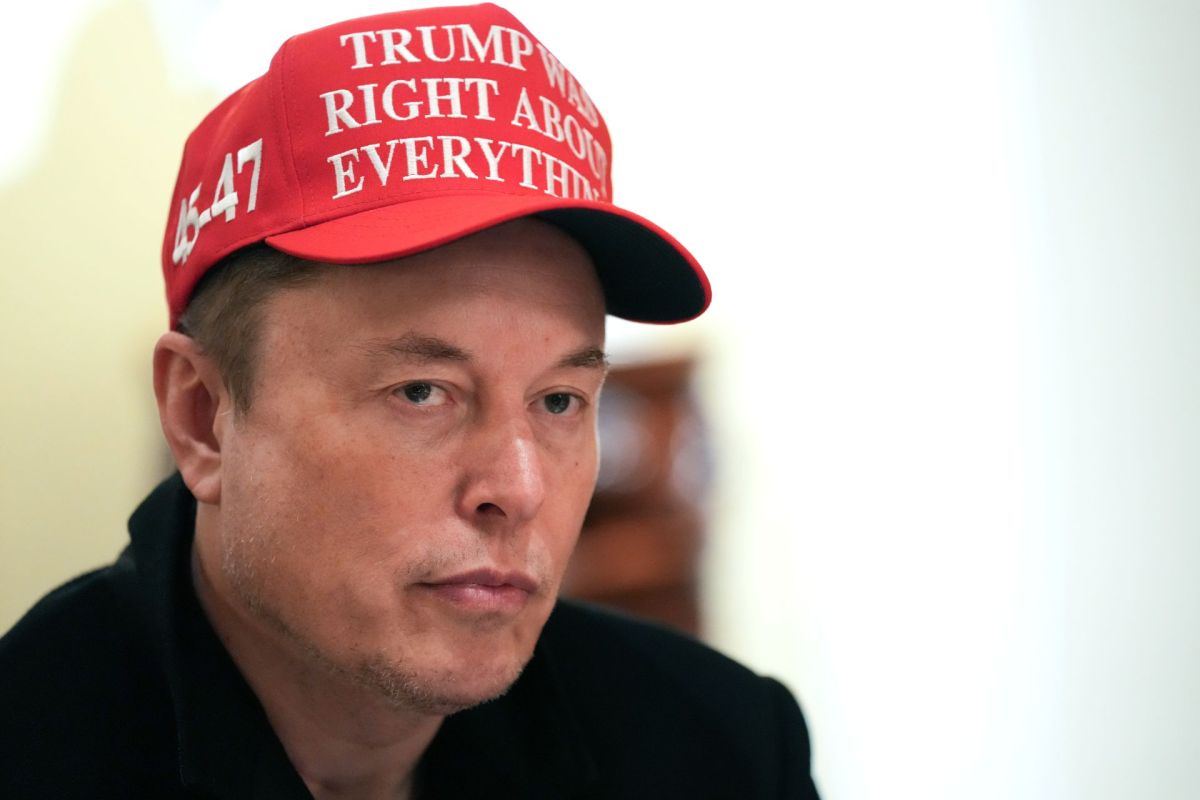 Elon Musk wearing a "Trump was right about everything" hat.