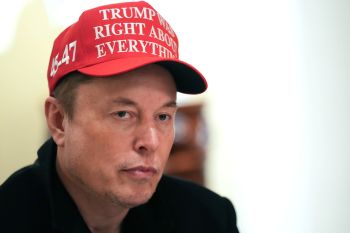 Elon Musk wearing a "Trump was right about everything" hat.
