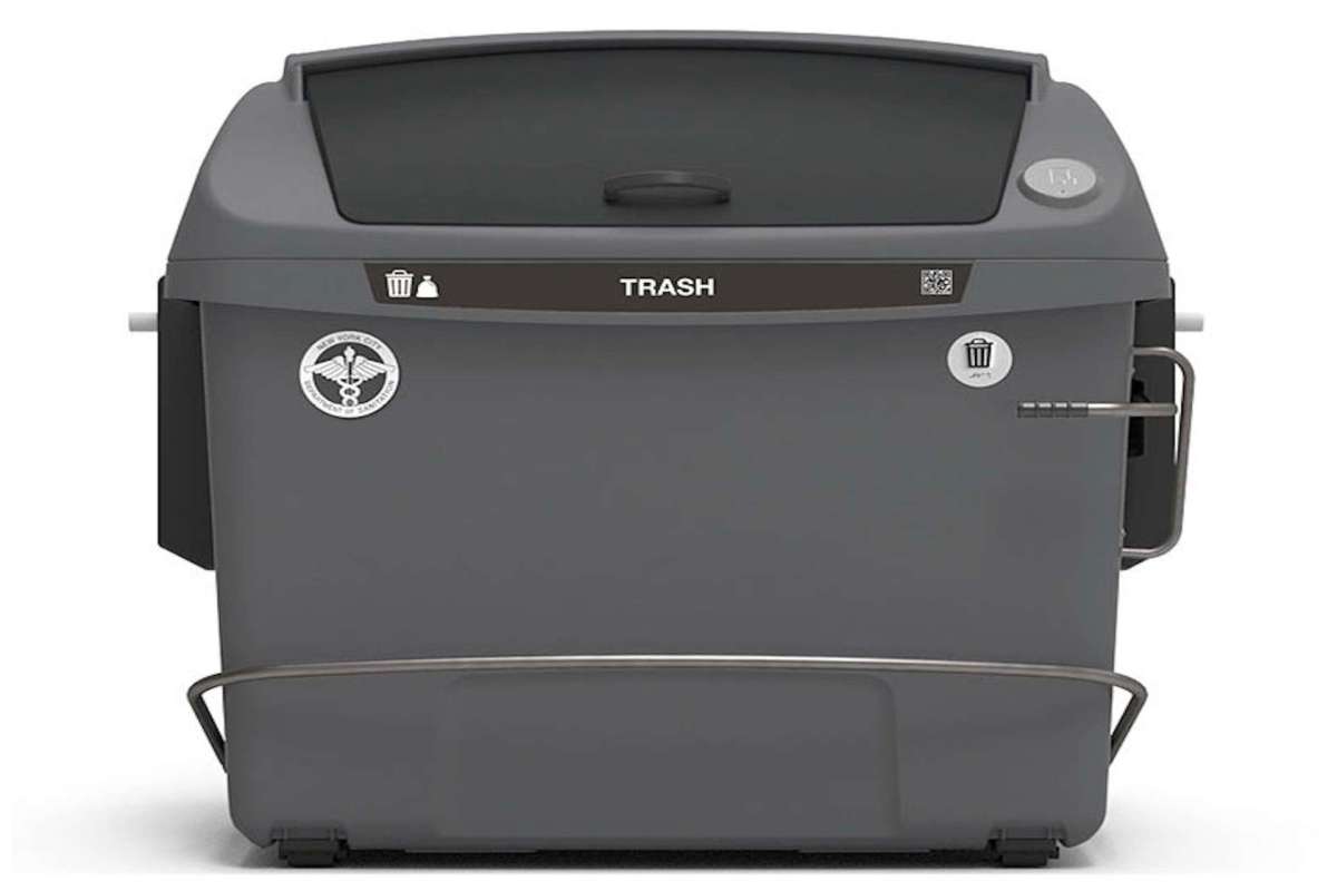 A gray trash bin with a lid and labels for disposal.