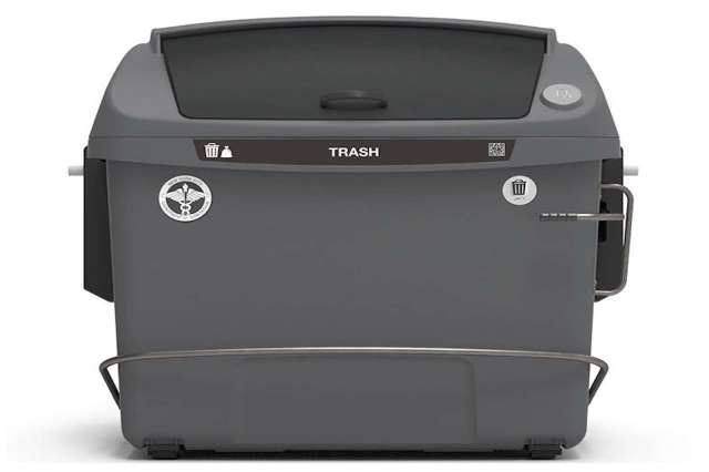 A gray trash bin with a lid and labels for disposal.
