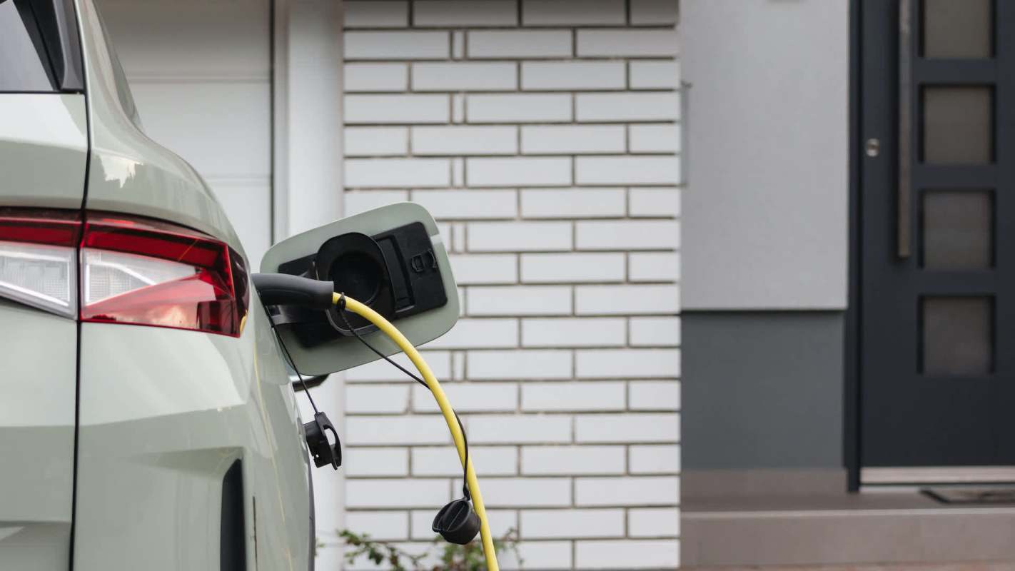 An electric vehicle is charging outside a modern home.