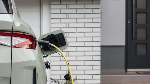 An electric vehicle is charging outside a modern home.