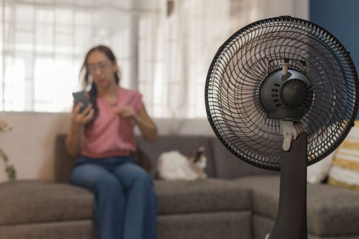 A person sitting in front of a fan.