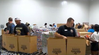 People packing boxes of food.