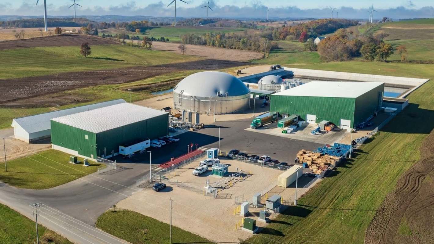 Aerial view of a bioenergy facility with multiple buildings and equipment in a rural landscape.