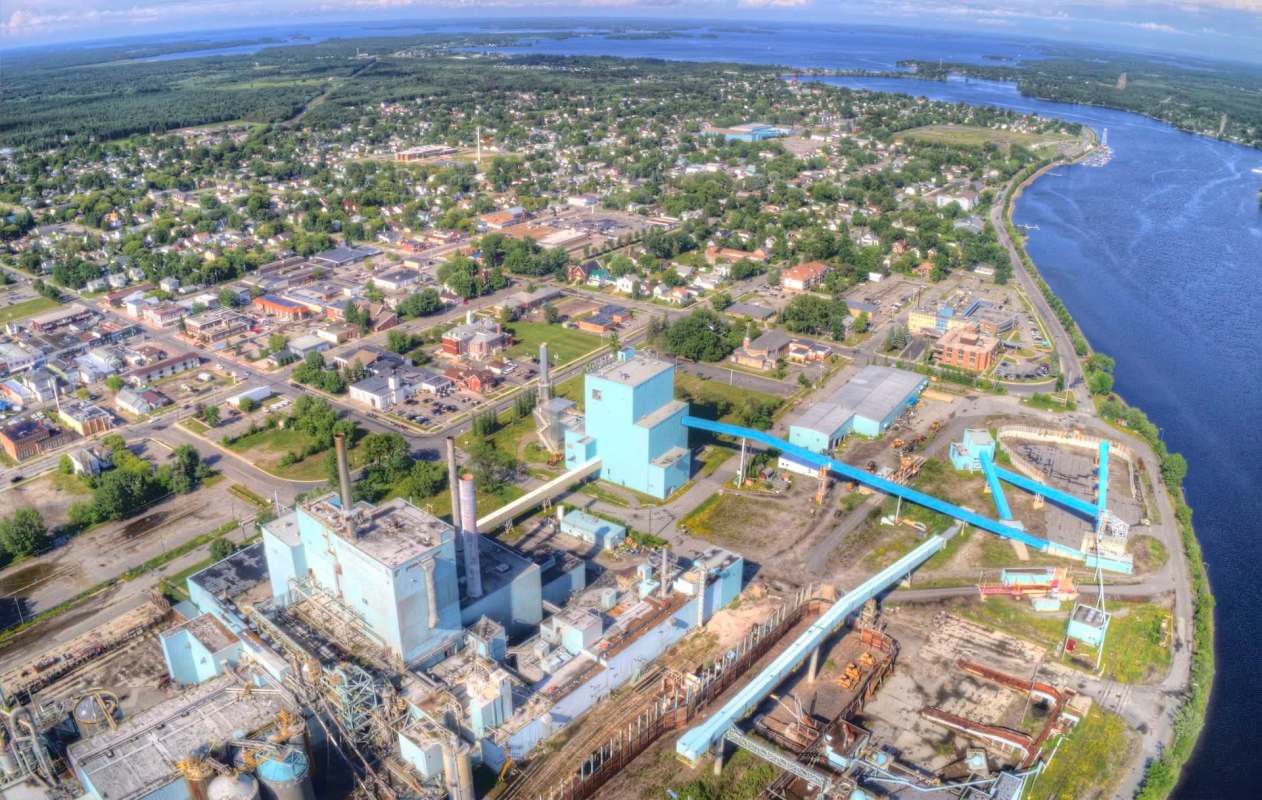 Fort Frances, Ontario, with a power plant, surrounded by residential neighborhoods and a river.