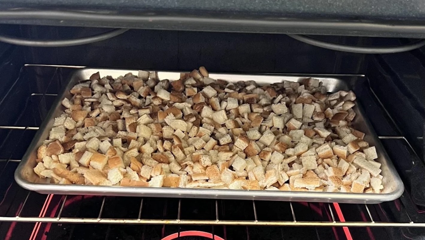 Cubed bread on a baking tray inside an oven.