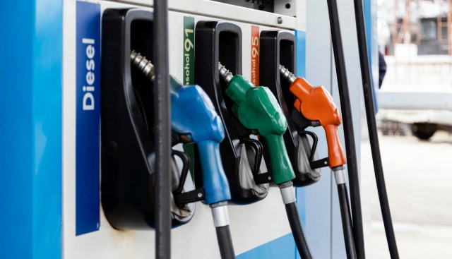Fuel dispensers with different colored nozzles labeled for diesel and gasoline types.