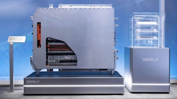 A large electric vehicle battery unit displayed next to smaller battery modules on a sleek platform.