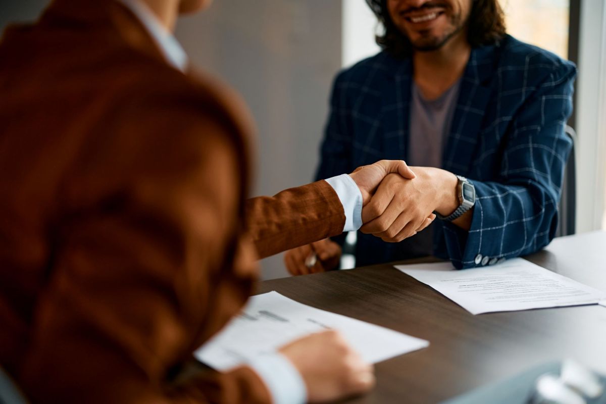 Two people shaking hands in an office.