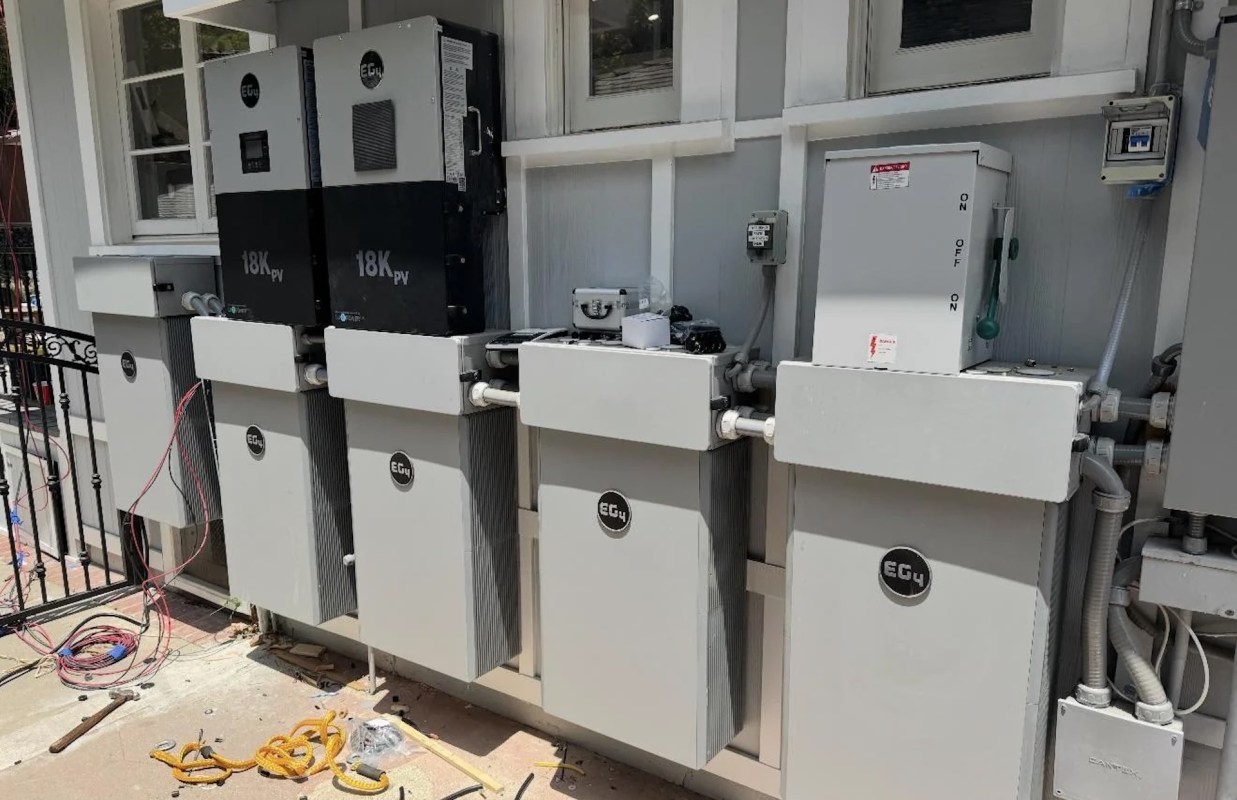 A series of electrical equipment and battery storage units mounted on a wall.