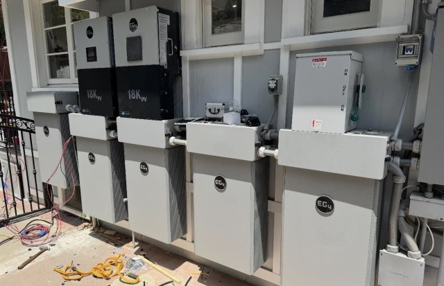 A series of electrical equipment and battery storage units mounted on a wall.