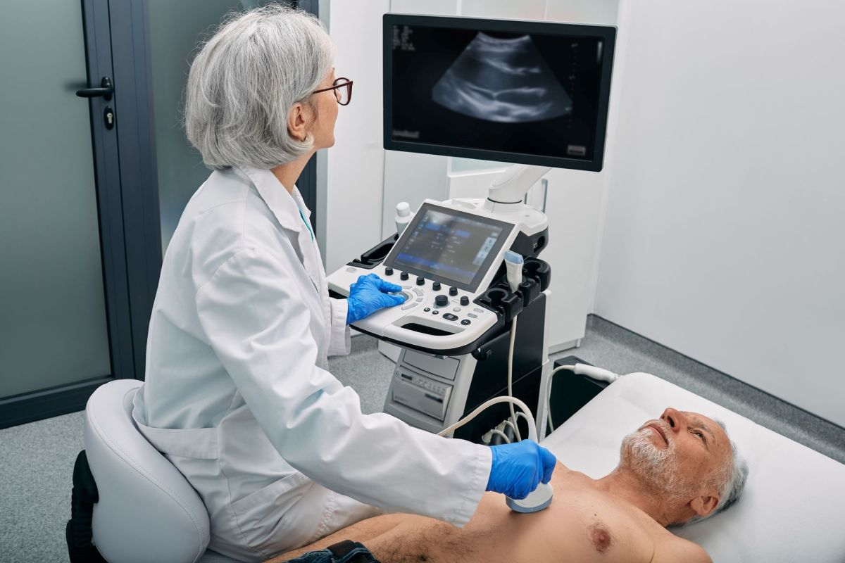 A medical professional performs an ultrasound on a patient's heart in a clinic.