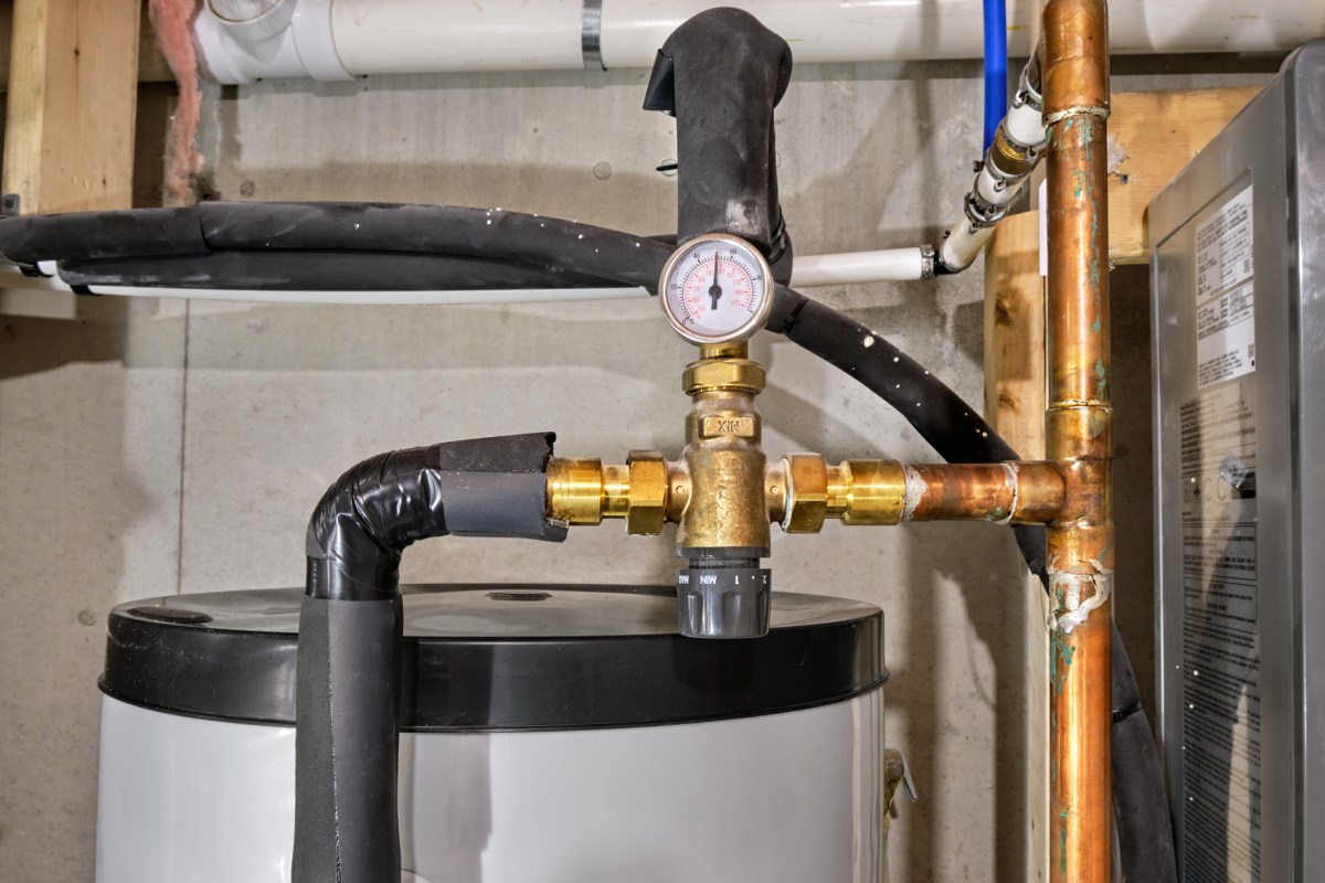 A plumbing system featuring pipes, a valve, and a pressure gauge connected to a water heater.