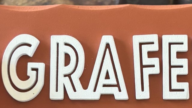 The word "GRAFE" is displayed in bold white letters on a reddish-brown background.