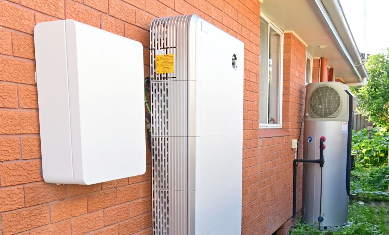 A solar inverter and battery bank near a heat pump water heater.