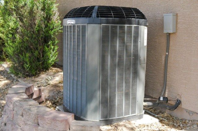 An HVAC outdoor unit sits outside a home