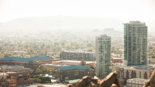 A view of a hazy cityscape with buildings and mountains in the background.
