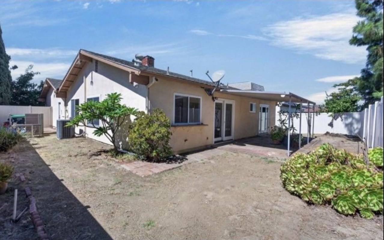 A house shown in a house listing with a dirt yard
