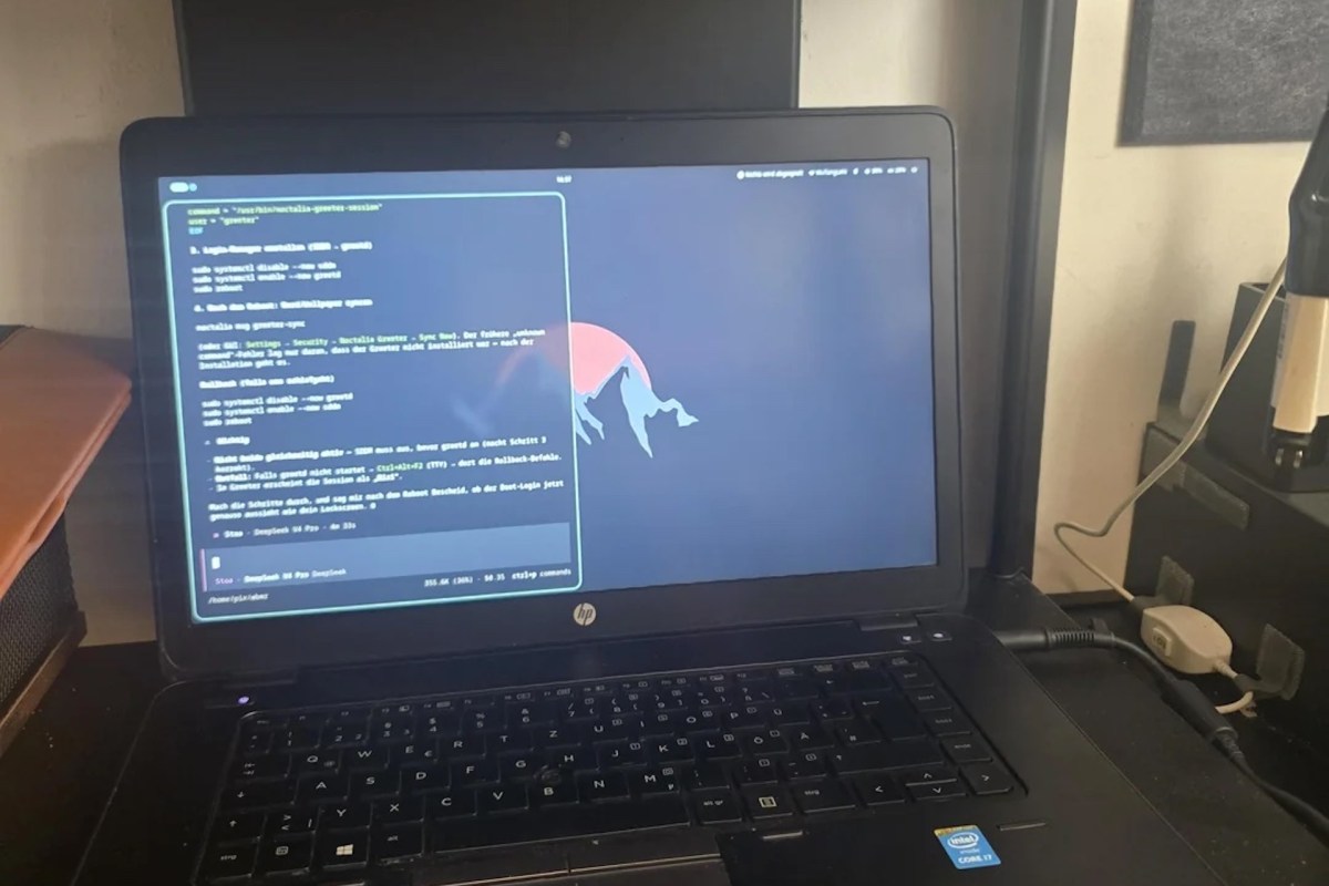 A laptop displaying a command-line interface with text in German on a colorful background.