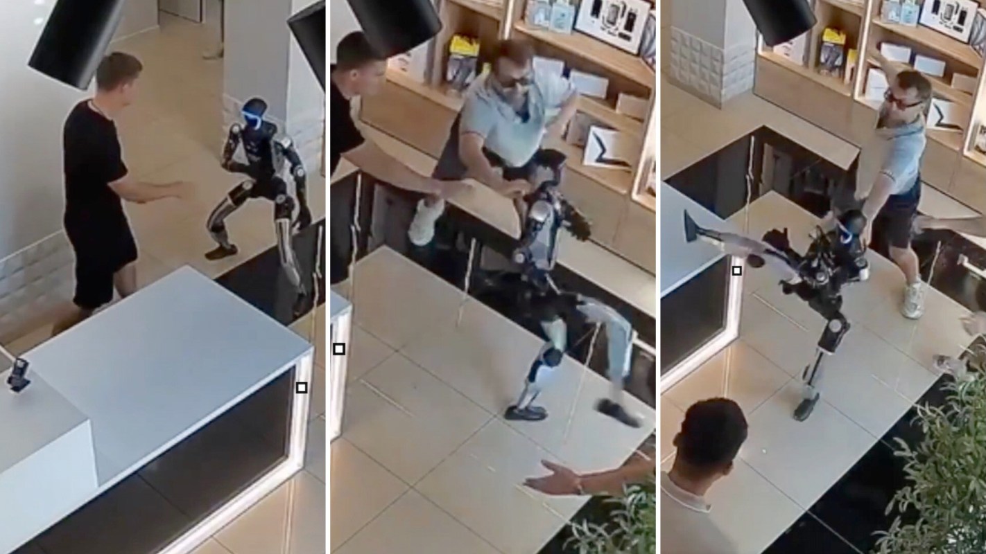 A man interacts with a robot in a modern indoor space, while another person watches.