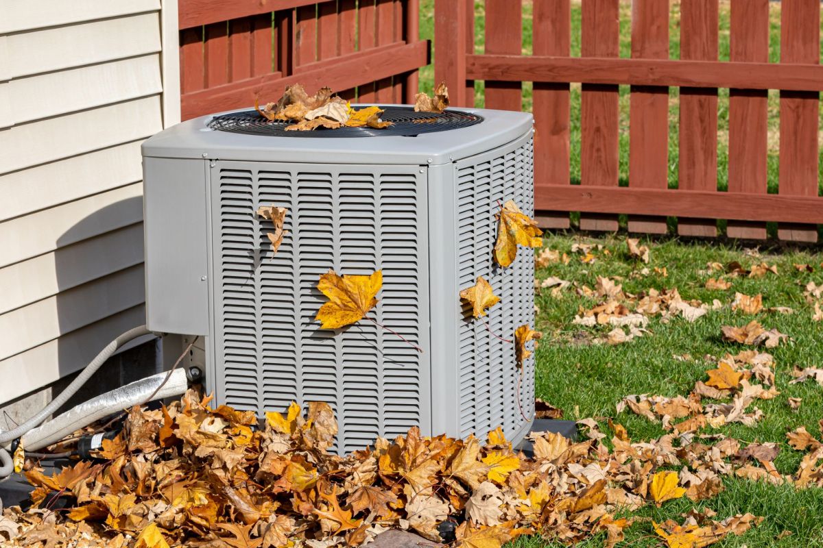 HVAC condenser outdoors with leaves