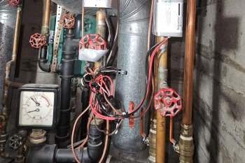Unwieldy wiring after a new installation of an HVAC system alongside valves and pipes