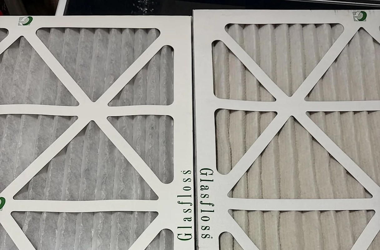 Two air filters with pleated media, one white and one light gray, displayed side by side on a surface.