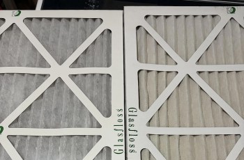 Two air filters with pleated media, one white and one light gray, displayed side by side on a surface.