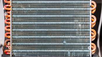 An industrial heat exchanger with copper pipes and metal fins.