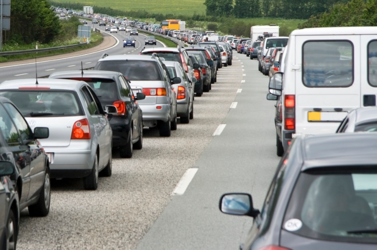 A line of vehicles idling in heavy traffic on a road.