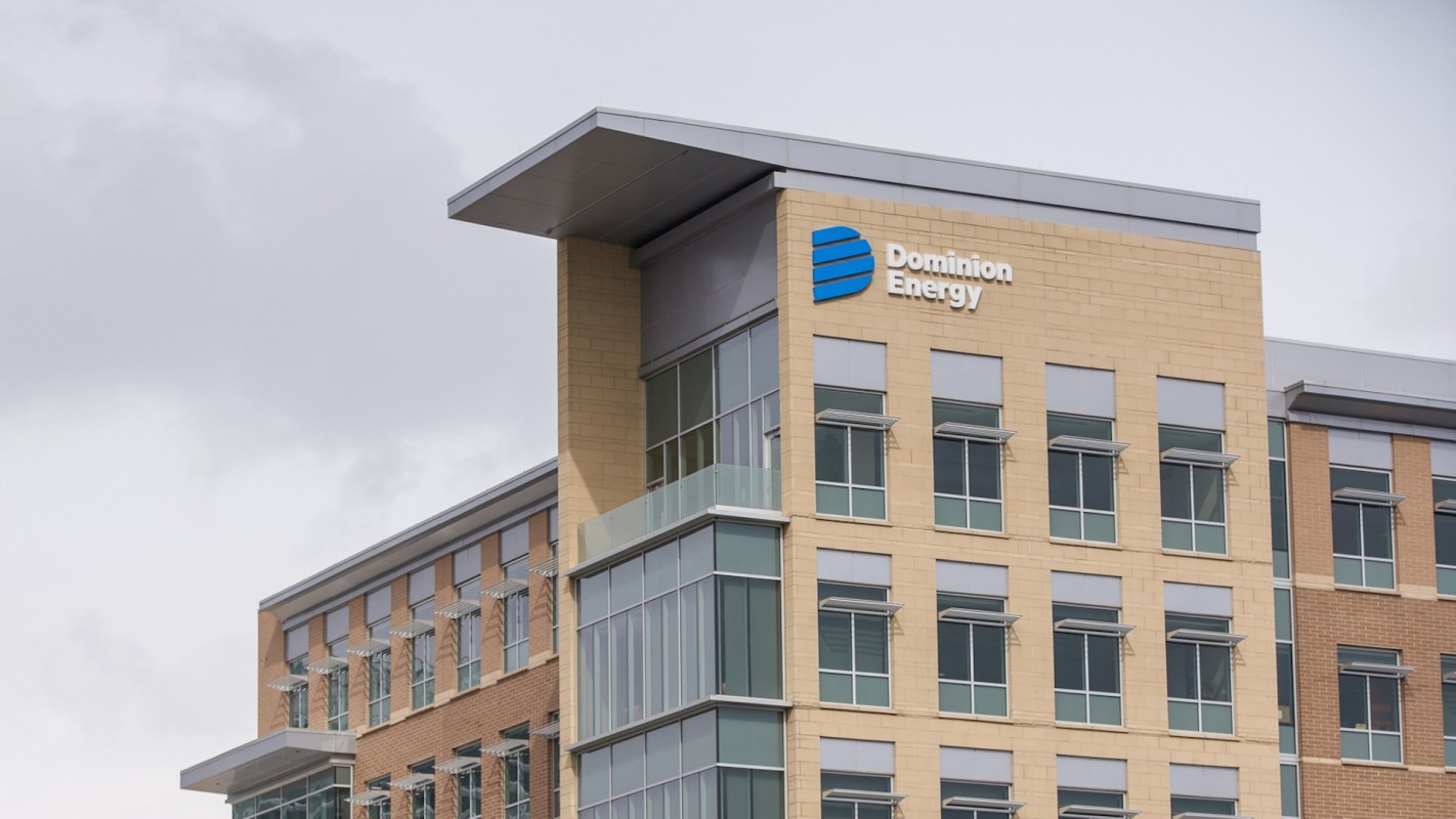 A building with the Dominion Energy logo and windows on a cloudy day.