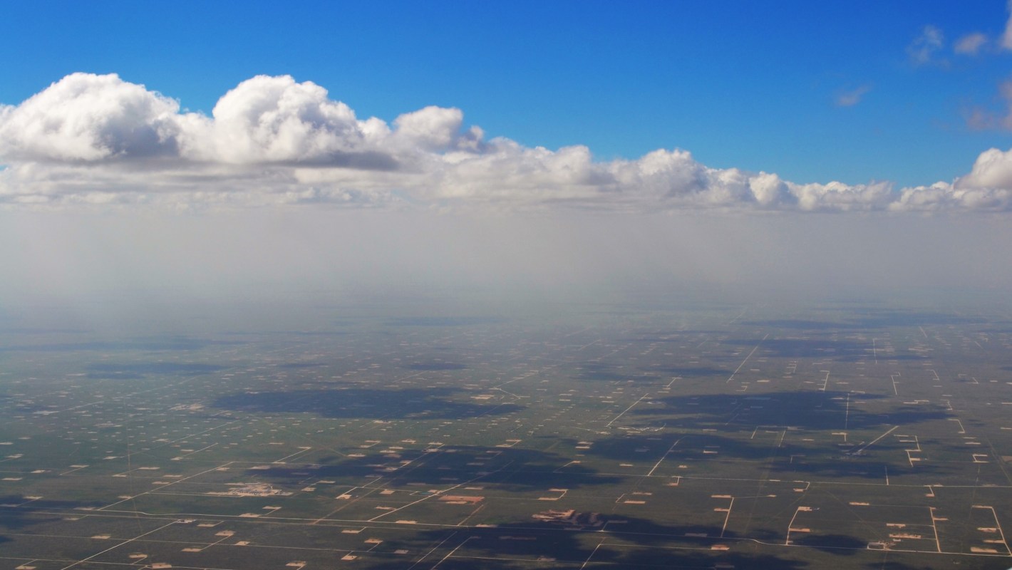 Clouds and haze over a large series of oil fields.