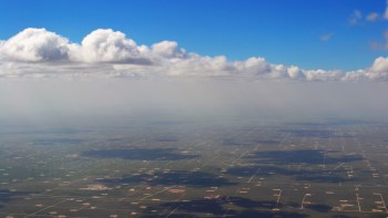 Clouds and haze over a large series of oil fields.