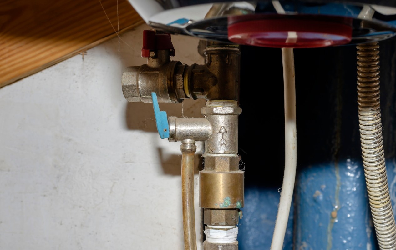A collection of plumbing valves and pipes mounted on a wall.