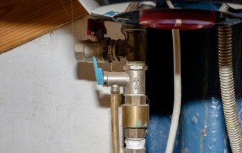 A collection of plumbing valves and pipes mounted on a wall.